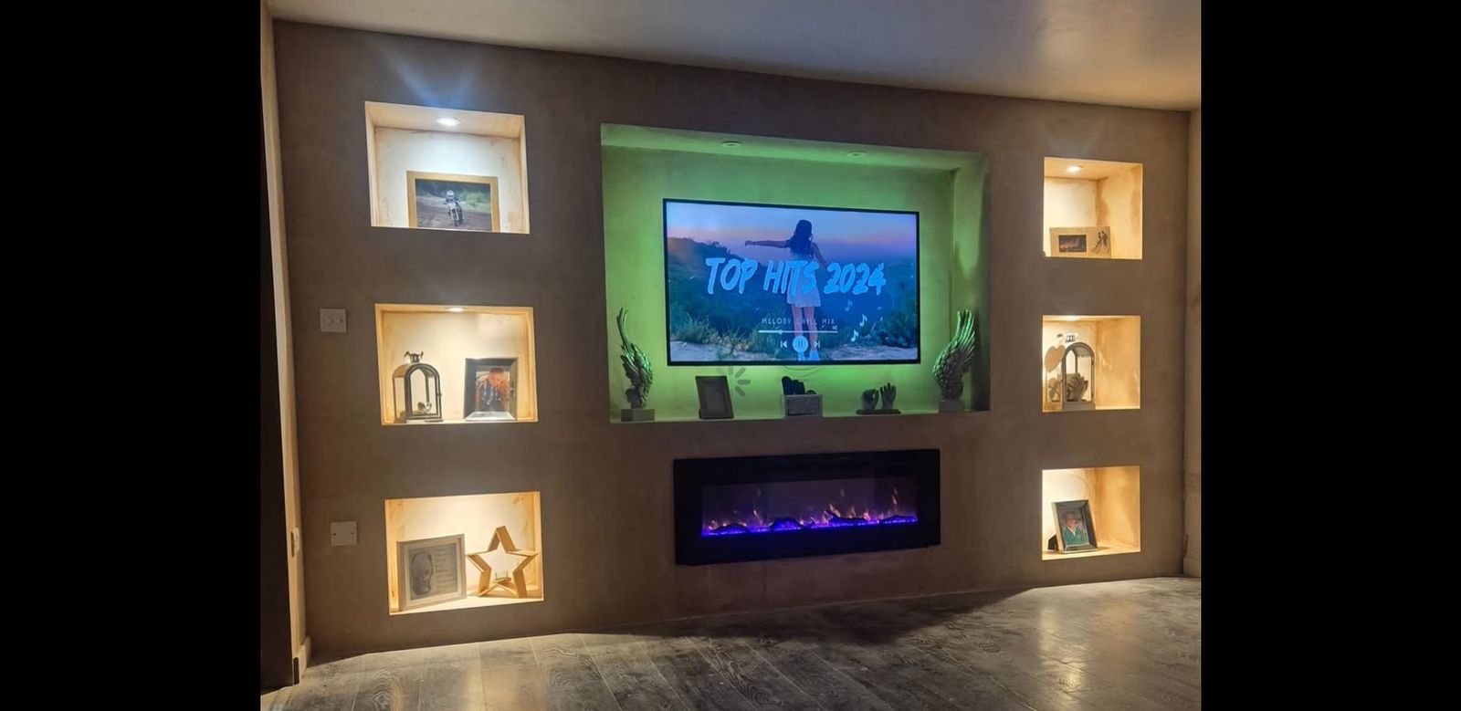 Bespoke media wall with lit display niches and inset electric fire by KCK Building Services